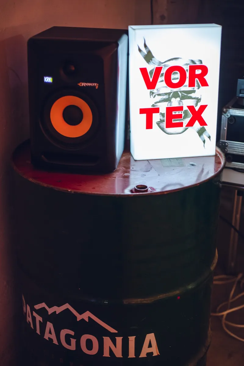 The Vortex lightbox next to a KRK studio monitor on top of a Patagonia barrel.